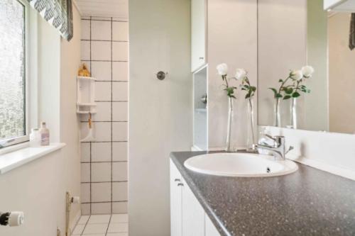 a white bathroom with a sink and a mirror at Cozy Farmhouse With Fantastic Surroundings, in Farsø