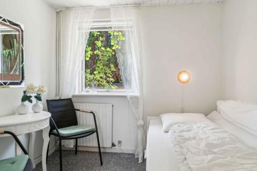 a bedroom with a bed and a desk and a window at Cozy Farmhouse With Fantastic Surroundings, in Farsø