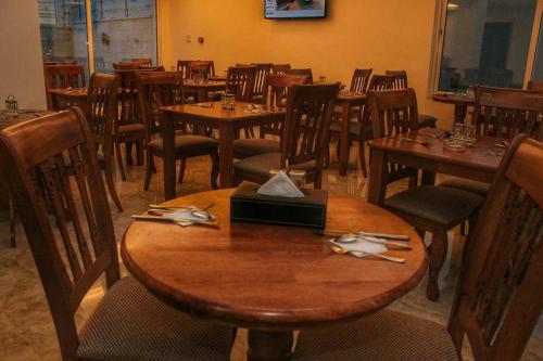 a dining room with wooden tables and chairs at Hotel Rayshan in Amman