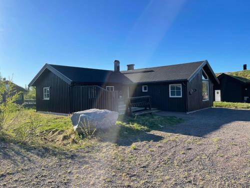 una casa negra con una valla delante en Beautiful cabin close to activities in Trysil, Trysilfjellet, with Sauna, 4 Bedrooms, 2 bathrooms and Wifi, en Trysil