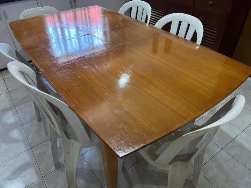 a wooden table with white chairs around it at SSC Transient House & Staycation - Imus in Imus