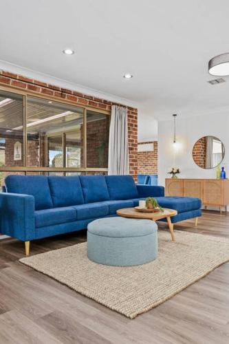 a living room with a blue couch and a table at The Lakehaus at Lyell in Bowenfels