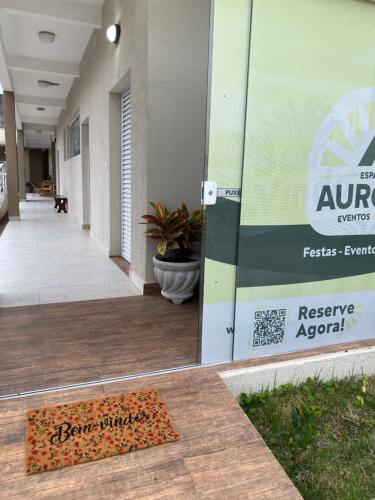 une entrée à un bâtiment avec un panneau sur la porte dans l'établissement Pousada e Espaco AURORA Peruibe, à Peruíbe
