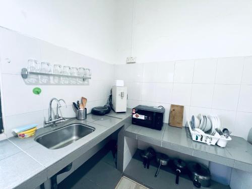 a kitchen with a sink and a counter top at SingVillage Holiday House in Mersing
