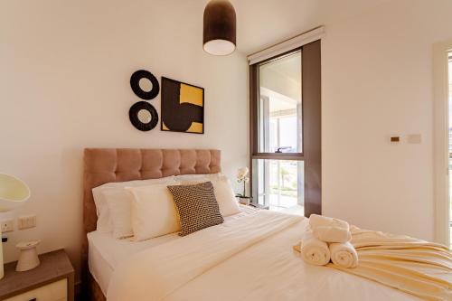 a bedroom with a bed with two towels on it at 2 Bed In Raha Lofts Hosted By Voyage in Abu Dhabi