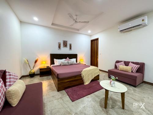 a hotel room with a bed and a couch at Guru Sadan A Luxe Stay in Ayodhya