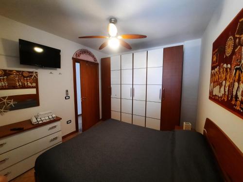 Un dormitorio con una cama y un ventilador de techo. en LaCasaDeiGechiOtranto, en Casamassella