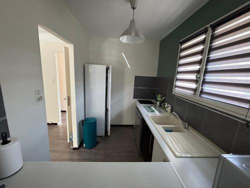 une cuisine avec un évier et un réfrigérateur dans l'établissement Gîte du Canal 6 personnes, à Vacqueyras