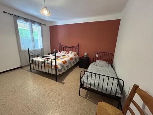 une chambre avec deux lits jumeaux et une fenêtre dans l'établissement Gîte du Canal 6 personnes, à Vacqueyras