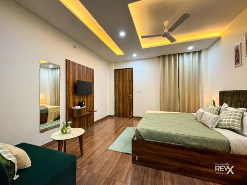 a bedroom with a bed and a ceiling fan at Guru Sadan A Luxe Stay in Ayodhya