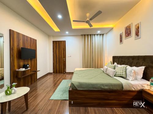 a bedroom with a bed and a television in a room at Guru Sadan A Luxe Stay in Ayodhya