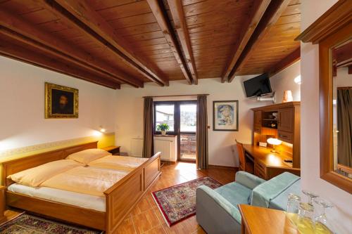 1 dormitorio con 1 cama y sala de estar en Hotel El Greco en Rožnov pod Radhoštěm