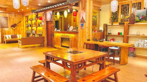 uma sala de jantar com mesas de madeira e uma lareira em 麦田间民宿Terrace View Hotel em Longsheng