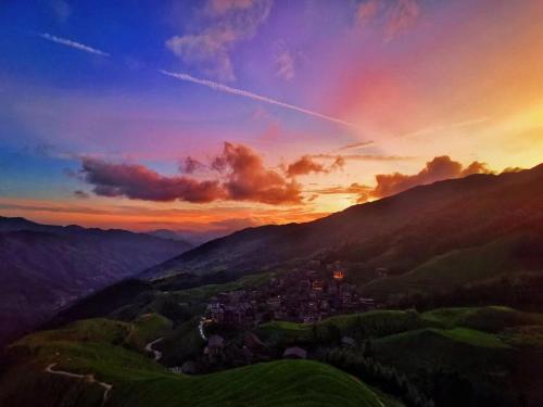 a view of a town in the mountains at sunset at 麦田间民宿 Terrace View Guesthouse in Longsheng