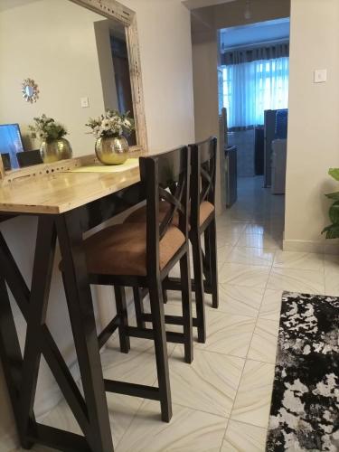 a dining room table with chairs and a mirror at Swanky Stays I in Nairobi