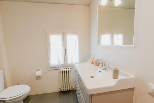 a bathroom with a sink and a toilet and a mirror at Forte 51 in Forte dei Marmi