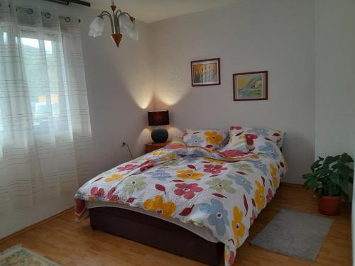 a bedroom with a bed with a floral comforter at Lana apartman in Jajce