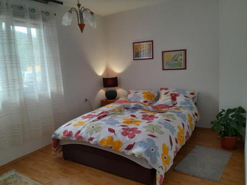 a bedroom with a bed with a floral comforter at Lana apartman Pijavice in Jajce