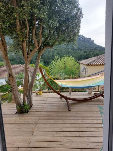 un hamac sur une terrasse avec deux arbres dans l'établissement Chambre indépendante avec terrasse privative, à Le Revest-le-Eaux