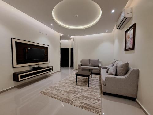 a living room with a couch and a flat screen tv at فندق لامير إن Lamer in Hotel in Sharurah