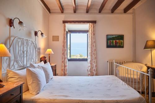 a bedroom with a white bed and a window at Can Busquets in Banyalbufar