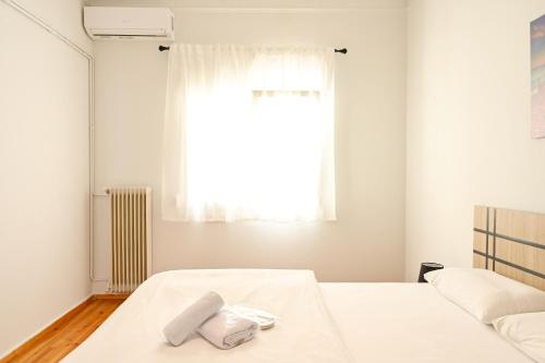 a bedroom with two white beds and a window at Thessaloniki Center Aristotelous Apartment in Thessaloniki