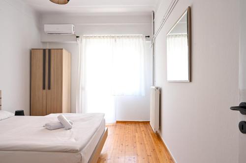 a bedroom with a bed and a large window at Thessaloniki Center Aristotelous Apartment in Thessaloniki