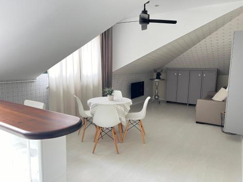 a dining room with a table and white chairs at Apartamentos Las Vegas in Ribadesella