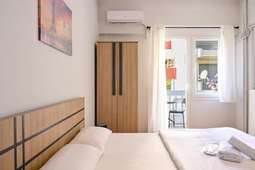 a bedroom with a bed and a door to a balcony at Thessaloniki Center Aristotelous Apartment in Thessaloniki