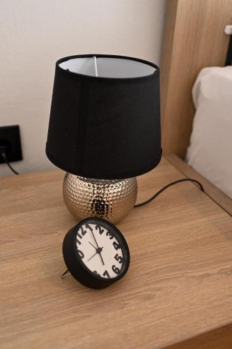 a lamp and a clock on a table at Thessaloniki Center Aristotelous Apartment in Thessaloniki