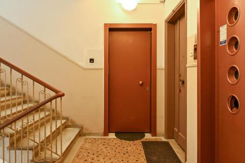 a hallway with a brown door and stairs at Thessaloniki Center Aristotelous Apartment in Thessaloniki