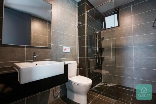 a bathroom with a toilet and a sink and a mirror at JOMSTAY Sunway Onsen Suites Ipoh - Lost World of Tambun Ipoh Waterpark in Tambun