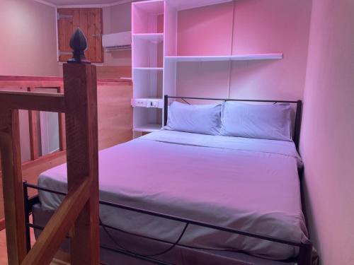 a bedroom with a bed with pink lighting at Hidden Heaven in village Krini in Kríni