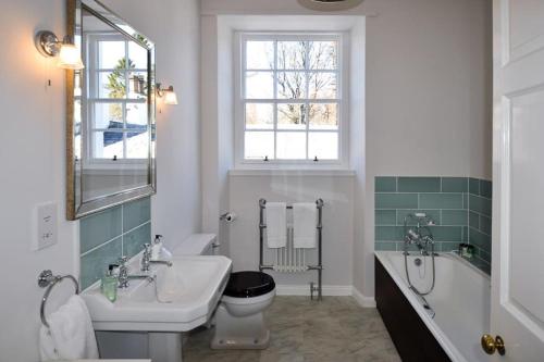 a bathroom with a sink and a tub and a toilet at Cray House - Large Country Home in Perthshire in Cray