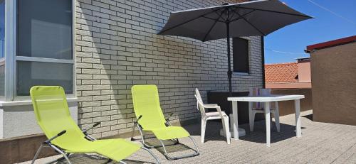 een patio met een tafel en stoelen en een parasol bij Casa da Praia in Póvoa de Varzim