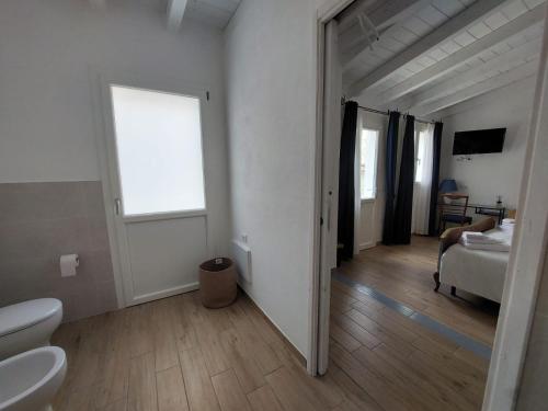 a white room with a bed and a window at B&B Il Borgo delle Emozioni in Dolianova