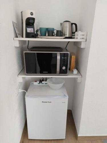 a microwave sitting on top of a refrigerator at B&B Il Borgo delle Emozioni in Dolianova