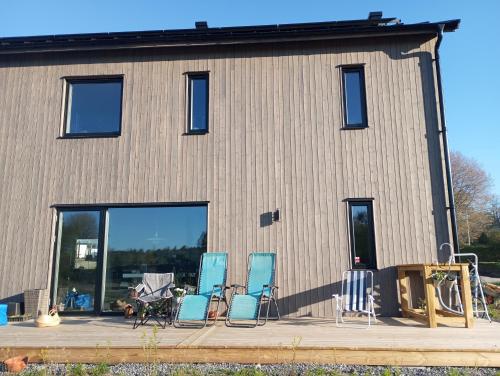 un grupo de sillas sentadas en una terraza frente a un edificio en Chill and stay en Ösmo