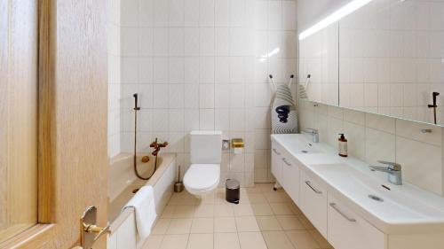 La salle de bains blanche est pourvue de toilettes et de 2 lavabos. dans l'établissement Zentrale 5,5 Zimmer Wohnung für bis zu 8 Personen, à Coire
