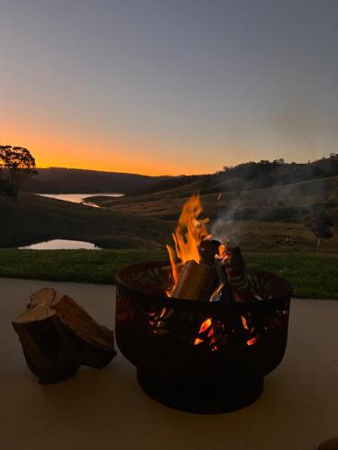 a fire pit on a table with the sunset in the background at The Lakehaus at Lyell in Bowenfels