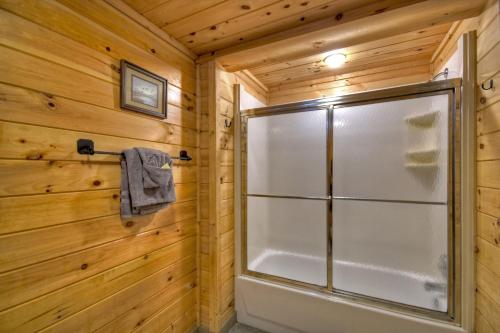 ein Bad mit einer Dusche an einer Holzwand in der Unterkunft K6 Lodge Gather around the firepit soak in the hot tub and splash in the creek in Blue Ridge