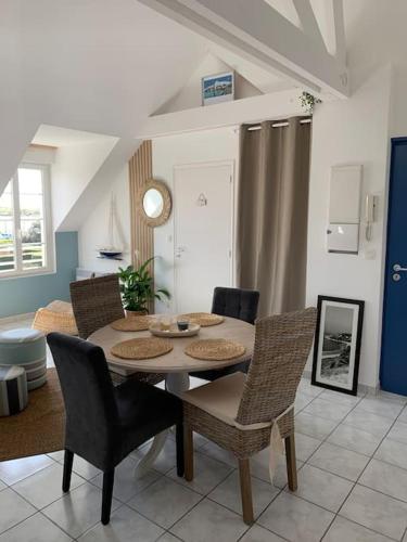 une table à manger et des chaises dans un salon dans l'établissement Plein Soleil, à Barneville-Carteret