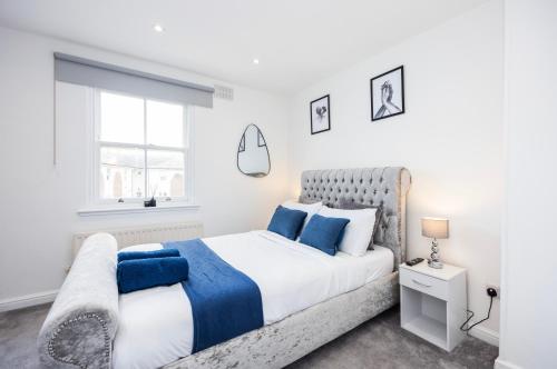 een witte slaapkamer met een groot bed en een raam bij Morden 2-Bed House in Canary Wharf London in Londen