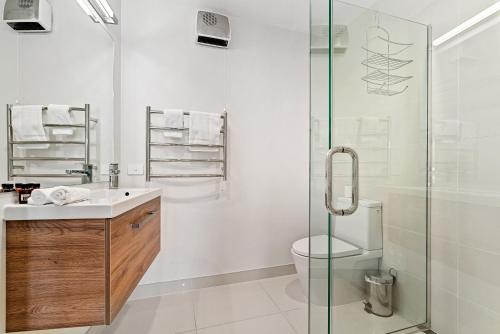 Un baño con inodoro y ducha de cristal. en Modern Luxe House with Magnificent View, en Queenstown