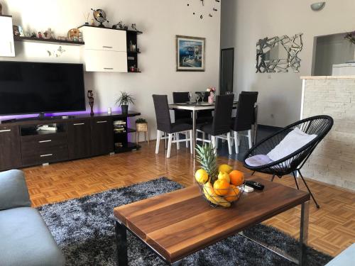 una sala de estar con una mesa con un bol de fruta. en Apartment Frane Podstrana with private pool, en Podstrana
