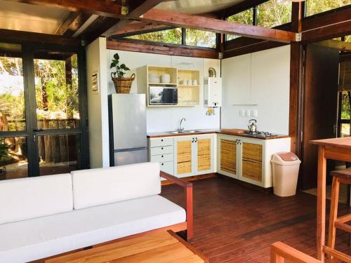 Ponta Membene في Machavene: مطبخ مع أريكة بيضاء وثلاجة