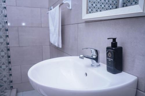 a bathroom sink with a soap dispenser on it at Safi Suites and Conference Centre in Mthatha