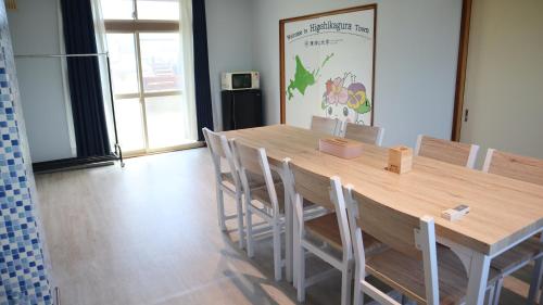 東神楽にある東神楽大学ゲストハウスの大きな木製テーブルと椅子が備わります。