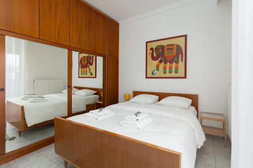 a bedroom with two beds with white sheets at Mimoza's Sea View Apartment in Paleo Tsifliki