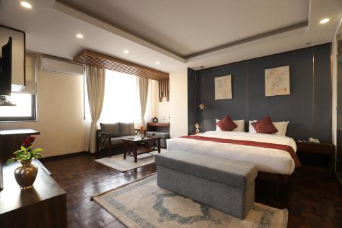 1 dormitorio con 1 cama extragrande y 1 silla en Apex Business Hotel, en Katmandú